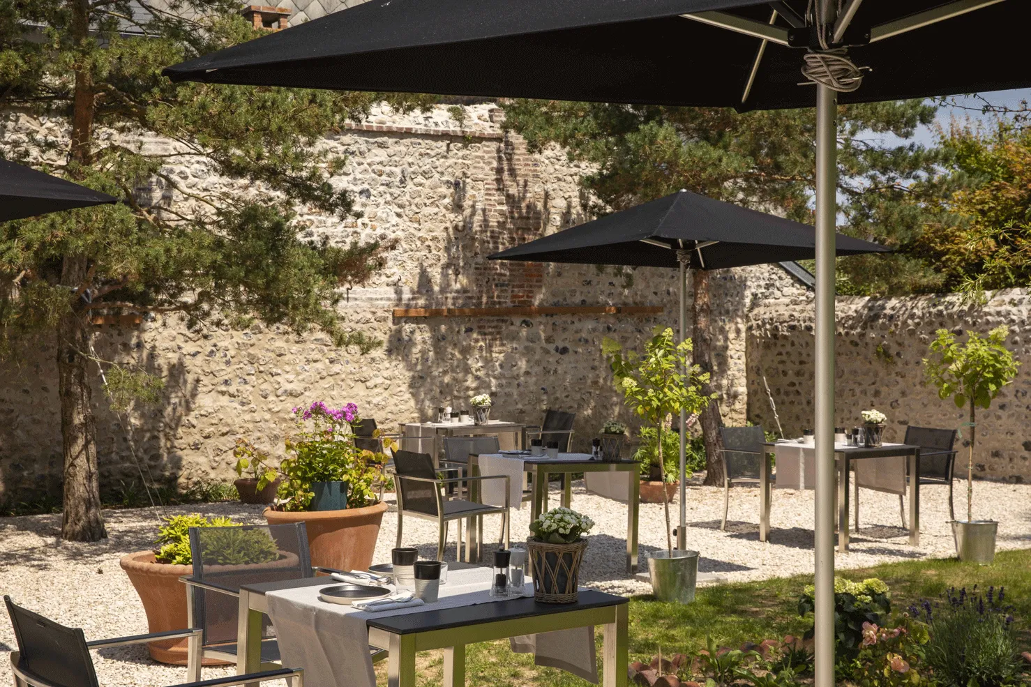 terrasse avec tables et chaises de l'hôtel Saint-Delis